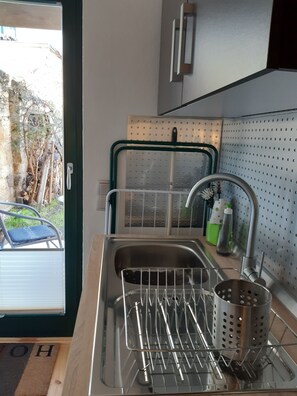 A kitchen with a stainless steel sink, a drying rack, and a colander. - Vacation Rental T19-Dresden (Dresden)