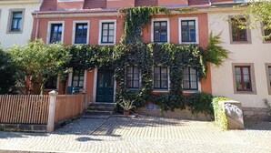 A row of terraced houses with a central entrance, a wooden fence, and a paved driveway. - Vacation Rental T19-Dresden (Dresden)
