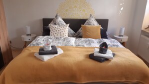 A neatly made bed with a patterned bedspread, two pillows, and two folded towels. - Vacation Rental T19-Dresden (Dresden)