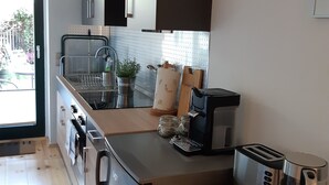A modern kitchen with stainless steel appliances, a built-in oven, and a coffee maker. - Vacation Rental T19-Dresden (Dresden)