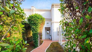 A pathway leading to a building with a white facade, a brick entrance, and a small window. - Villa Medea in Vabriga - Haus für 4 Personen (Vabriga)