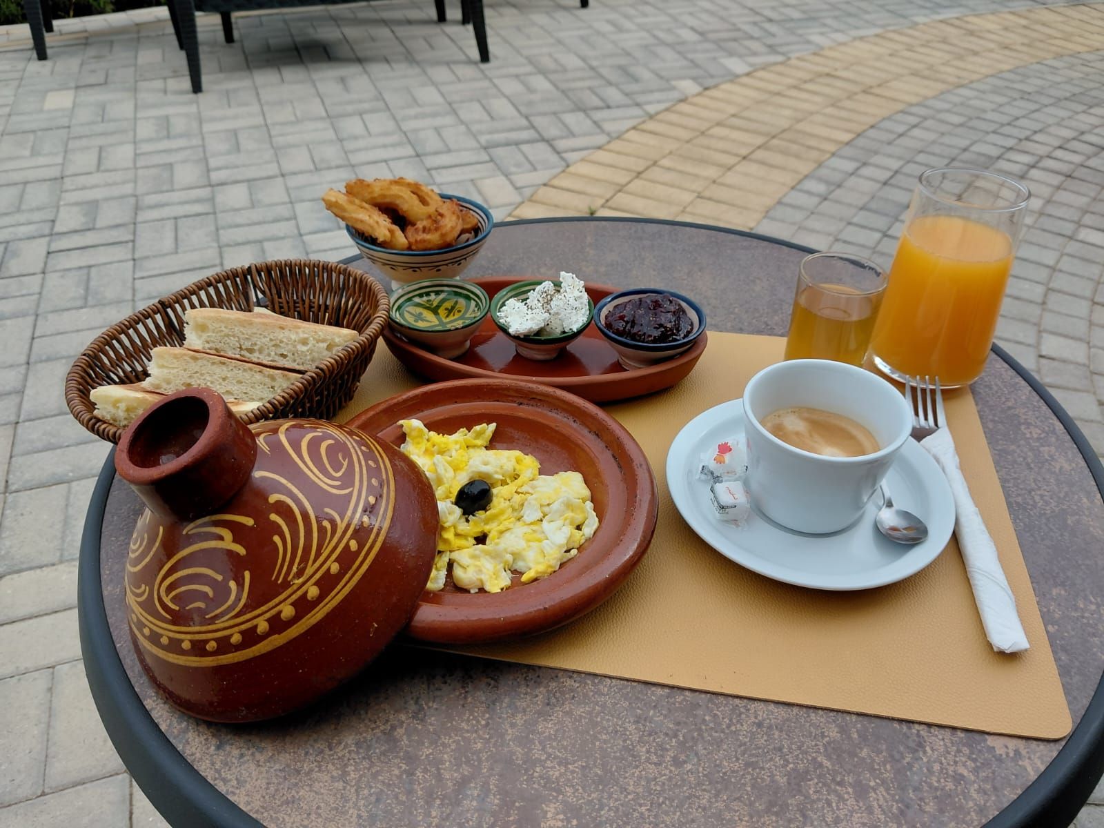 Pöydällä on aamiaistarvikkeita, kuten leipää, kananmunia, juustoa ja kuppi kahvia.