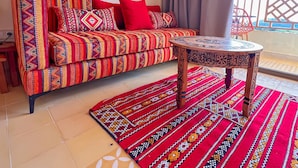 A living area with a sofa, a coffee table, and a patterned rug.