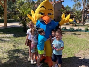 A mascot with a large orange beak and blue outfit standing in a grassy area with children. - Mobile home, pets welcome - 4 guests (Carcans)