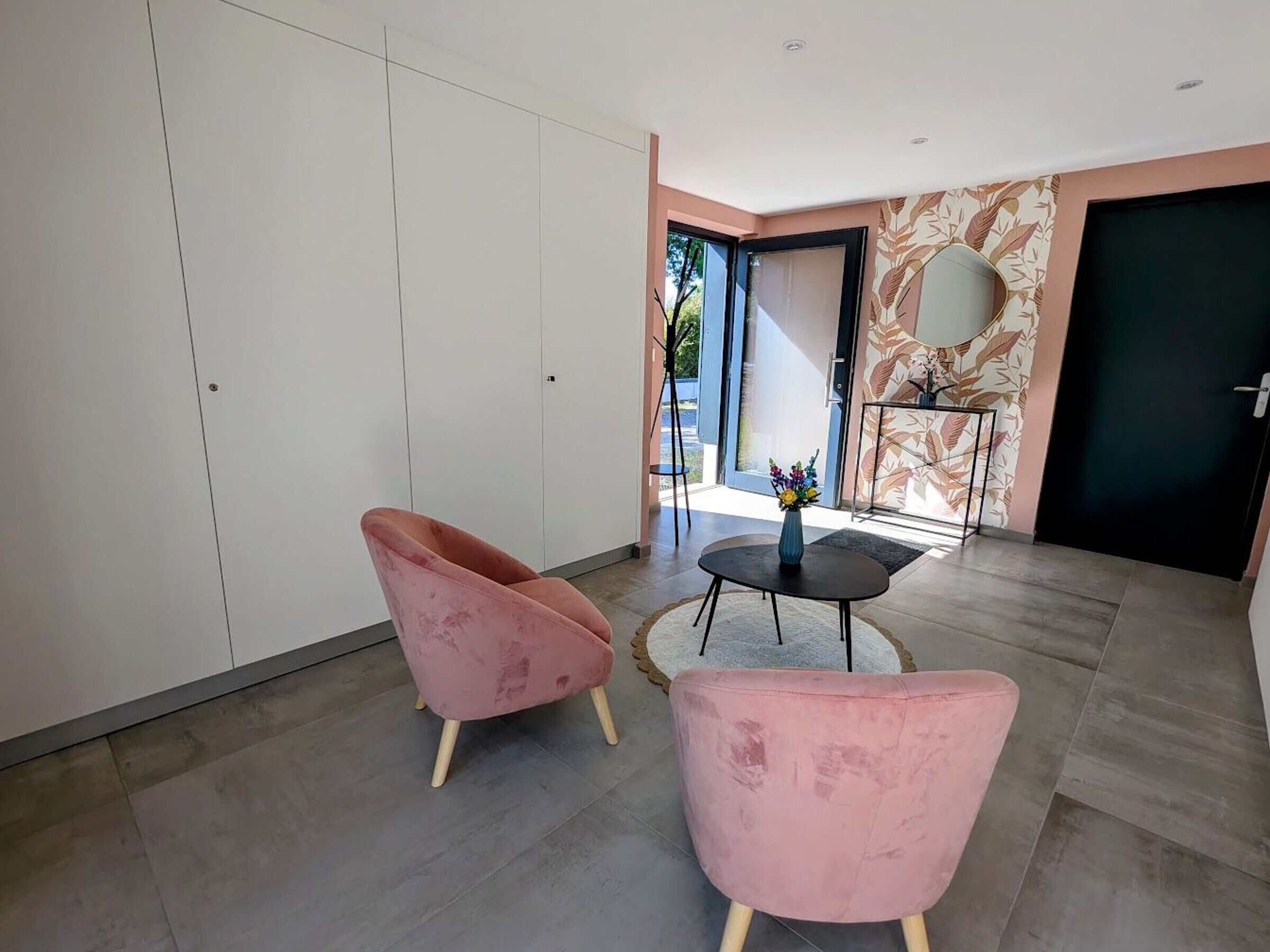 Un interior modern amb una zona de seients, un armari ampli i un mirall decoratiu.
