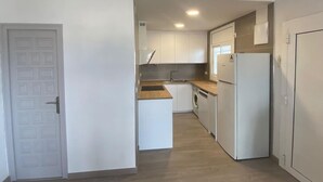 A compact kitchen with white cabinets, a sink, a washing machine, and a refrigerator. - Beautiful 2-bed apt with sea view, glassed-in terrace, parking, 750m from the beach in Roses (Roses)