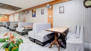 A restaurant with booths, tables, and a clock on the wall. - Collection O Tourist Complex Area (Agra)
