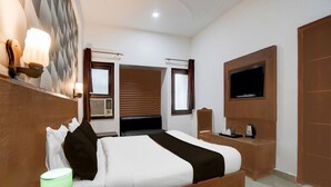 A hotel room with a bed, a TV, a desk with a kettle, and a window with blinds. - Collection O Tourist Complex Area (Agra)