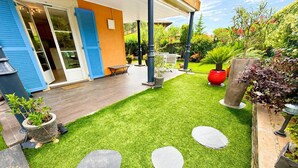 A well-maintained garden with artificial grass, stone stepping stones, and potted plants. - Charming apartment, air conditioning - 2 guests (La Croix-Valmer)