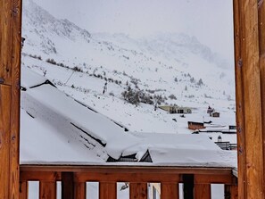 Eine verschneite Berglandschaft mit Gebäuden und einem Holzzaun.