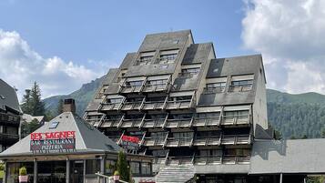 A multi-story building with balconies, a bar, and a restaurant.