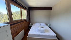 Un dormitorio con una cama, una mesita de noche, una lámpara, una ventana y un radiador.