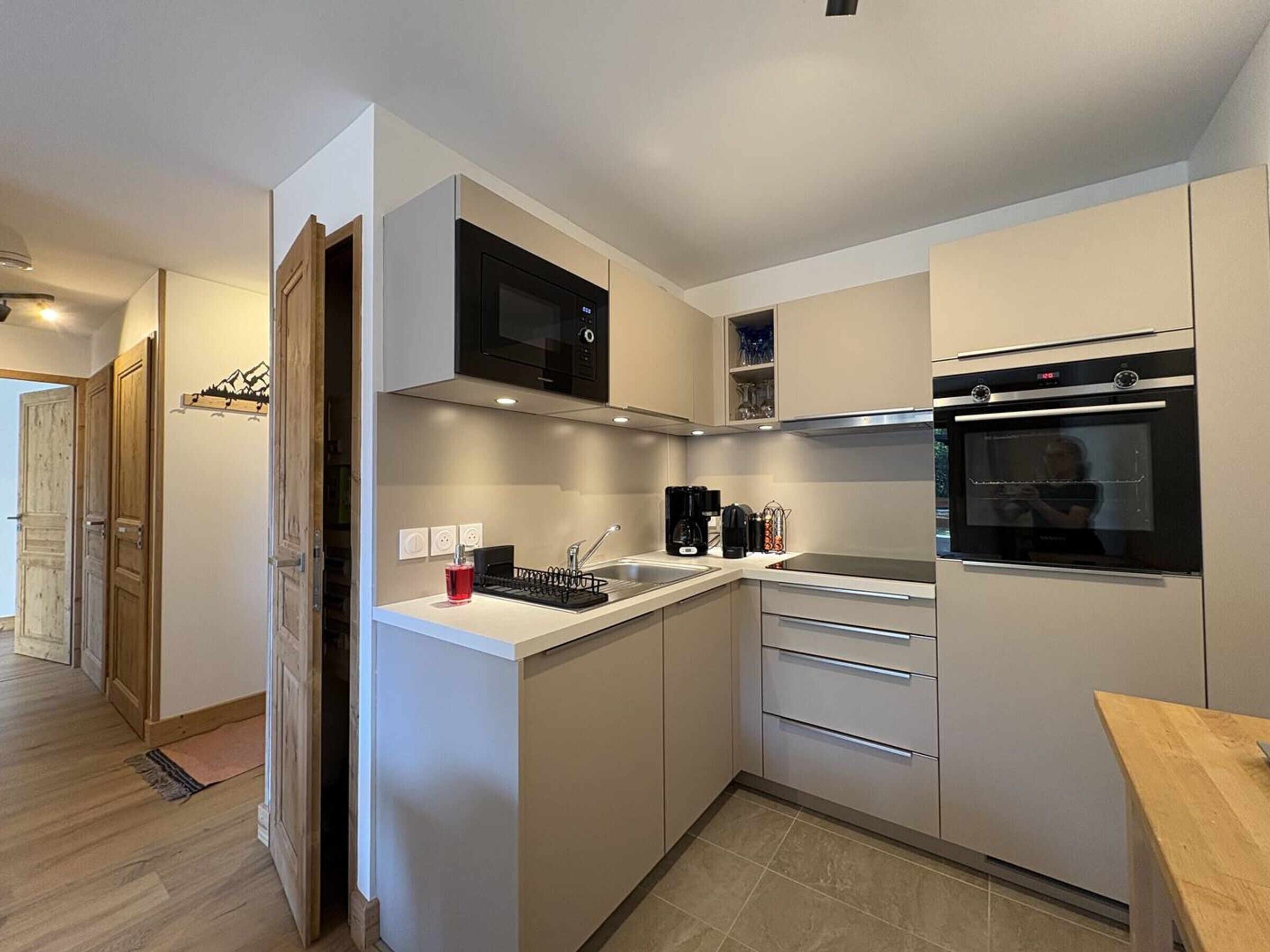 A modern kitchen with a microwave, oven, and sink.