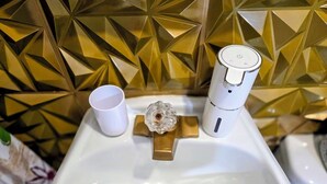 A bathroom sink with a faucet, a cup, and a soap dispenser. - Ahoy kids! Pirate's Grotto Apartment by Airport and Stadium (Tampa)