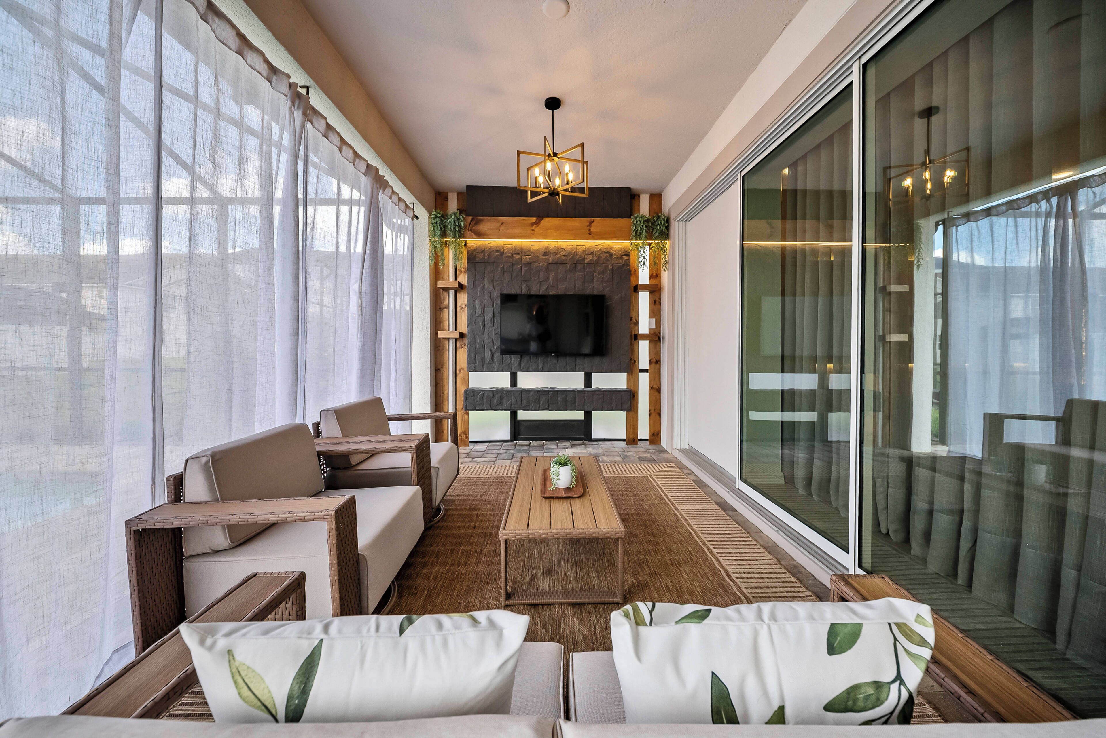 A modern living room with a fireplace, a flat-screen TV, and comfortable seating.