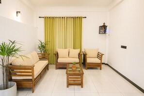 A living room with a sofa, two armchairs, a coffee table, and a potted plant. - 5bedroom apartment with AC in amazing Negombo - SkyPort Villa Negombo (Negombo)