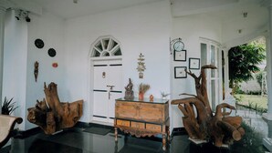 Una habitación con una puerta blanca, un armario de madera y una gran escultura de tronco de árbol.