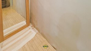 Un pasillo estrecho con techo y marco de puerta de madera.