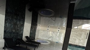 Un área de spa con hidromasaje, sillones reclinables y piscina.