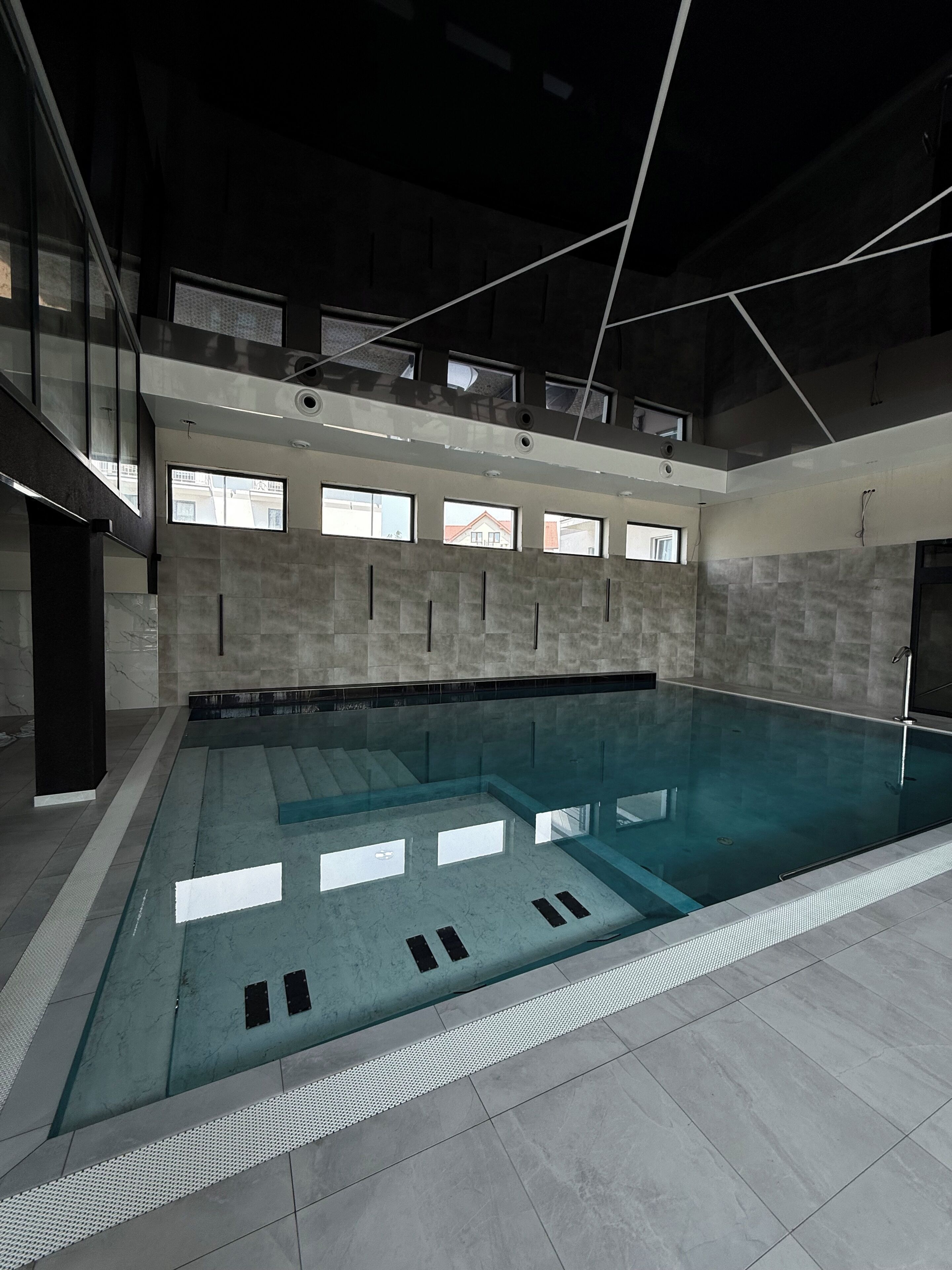 An indoor swimming pool with a clear view of the surrounding walls and windows.