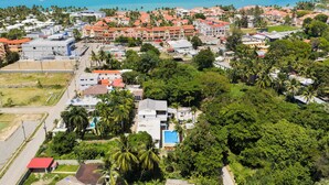 Une vue aérienne d’une ville côtière, avec ses bâtiments, une piscine et une route.