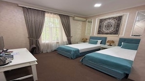 A hotel room with two beds, a desk, a chair, an air conditioning unit, and a window with curtains. - La Casa Boutique Nizami (Baku)