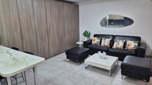 A modern living room with a sofa, two ottomans, a coffee table, and a dining table. - 2 minutes from the beach: Charming apartment with outdoor space and secure parking (Antibes)
