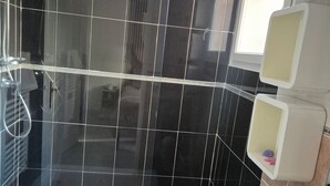 A bathroom with a bathtub, a shower, and a toilet. - 2 minutes from the beach: Charming apartment with outdoor space and secure parking (Antibes)