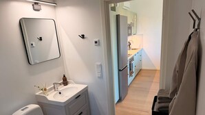 Un baño con inodoro, lavamanos, espejo y barra para toallas.