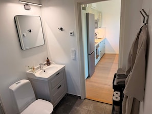 A bathroom with a toilet, sink, mirror, and towel rack. - 5 Star Holiday Home in Akersberga (Akersberga)