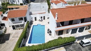 A residential building with a swimming pool, tiled roofs, and a white exterior. - #394 Albufeira Escape | 3-Bedroom Villa with Shared Pool (Albufeira)