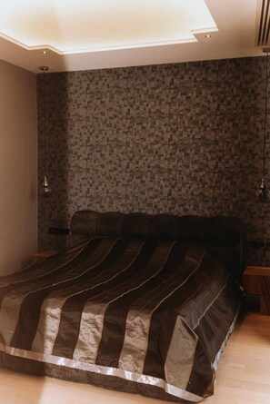 Ein Schlafzimmer mit einem großen Bett, einer Wand mit Muster und einem Oberlicht.