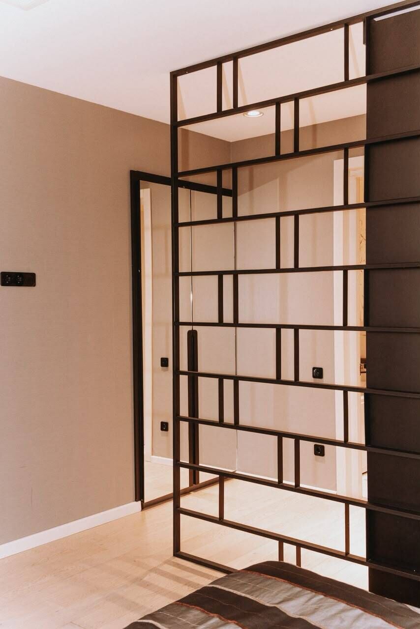 Una habitación con una pared corredera, piso de color claro y pared oscura.
