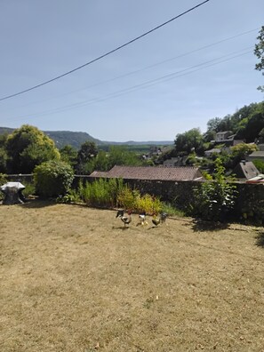 A rural setting with a house, a stone wall, and a grassy yard. - La Grange Vacation Rental in the Périgord Noir (Allas-les-Mines)