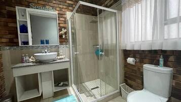 Luxe suite, uitzicht op park | Badkamer | Een aparte badkuip en douche, een haardroger, handdoeken, zeep