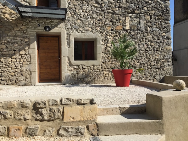 A stone building with a wooden door and a small window. - A Different Side of the Ardèche: A Unique Retreat with a Terrace (Baix)
