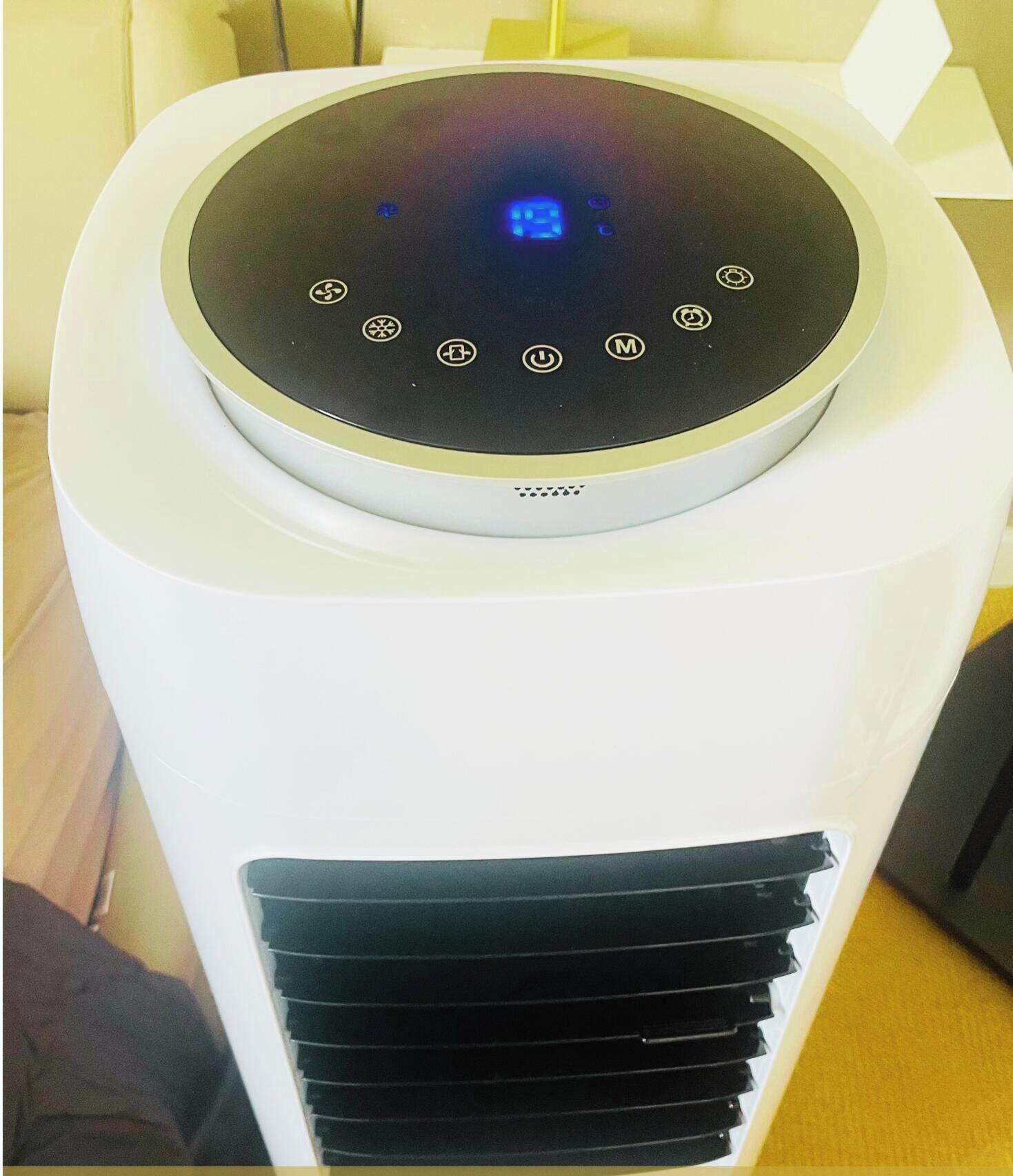A white air purifier with a circular control panel and a vent at the bottom.