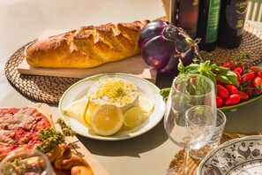 A table with food items, a glass of water, and a bottle of wine. - Fior di Noto, Golden Luxe Sicily (Noto)