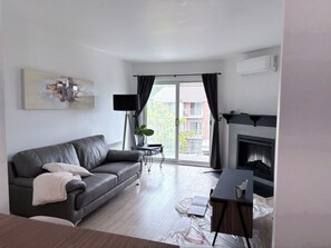 Ein modernes Wohnzimmer mit einer Ledersofa, einem Kamin und Blick ins Freie.