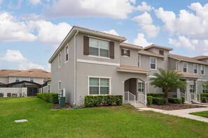 A residential building with a flat roof, multiple windows, and a well-maintained lawn. - Storey Lake 2BR Condo Near Disney Parks (Kissimmee)