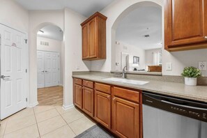 Una cocina con muebles de madera, lavavajillas y encimera.