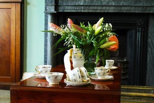 Una mesa con arreglos florales y servicio de té.