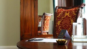 A wooden desk with a pen, a glass bottle, a card, and a small bowl.