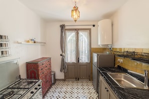 Comfort Apartment, Garden View | Private kitchen | Cleaning supplies, dining tables