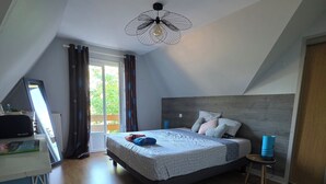 A bedroom with a bed, a desk, a chair, a small stool, a rug, and a ceiling fan. - Lake View, Spacious House with Garden (Châtellerault)