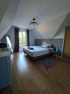 A bedroom with a bed, a desk, a chair, a small stool, a rug, and a ceiling fan. - Lake View, Spacious House with Garden (Châtellerault)