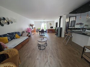 A modern living room with a sofa, a dining area, and a kitchen. - Lake View, Spacious House with Garden (Châtellerault)