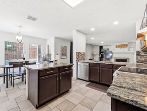 A modern kitchen with granite countertops, dark cabinetry, and a dishwasher. - Corinth Oasis Getaway - 4 Bedrooms (Corinth)
