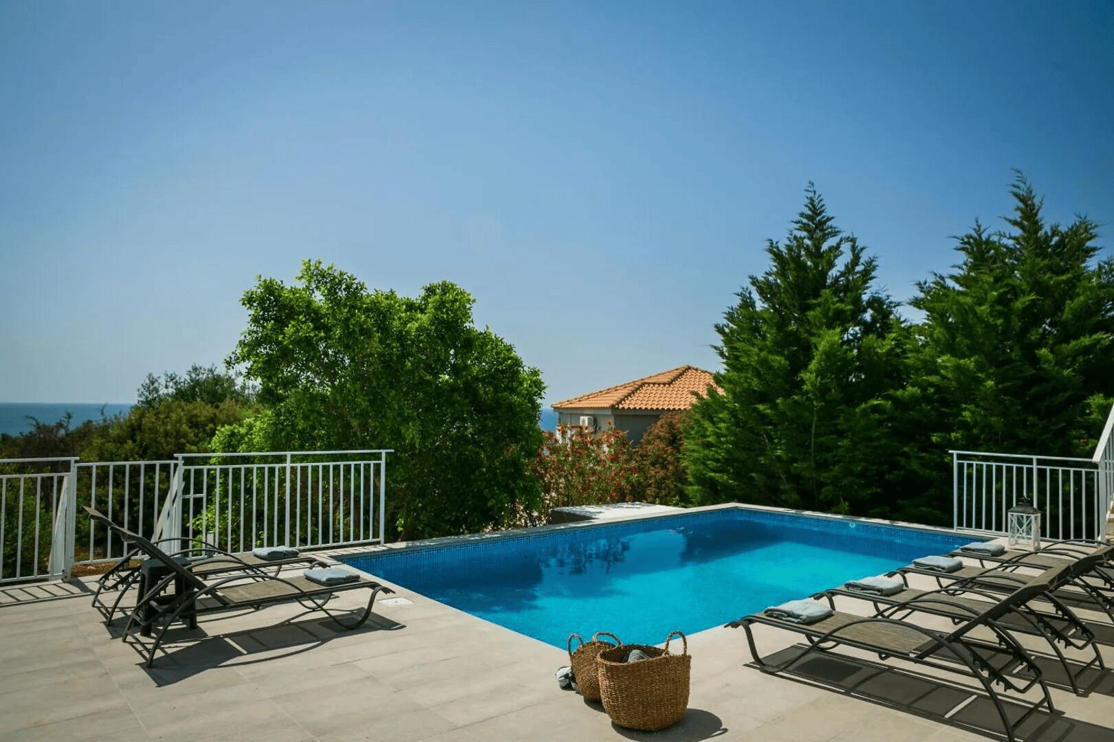 Una piscina con lettini e vista sul mare.