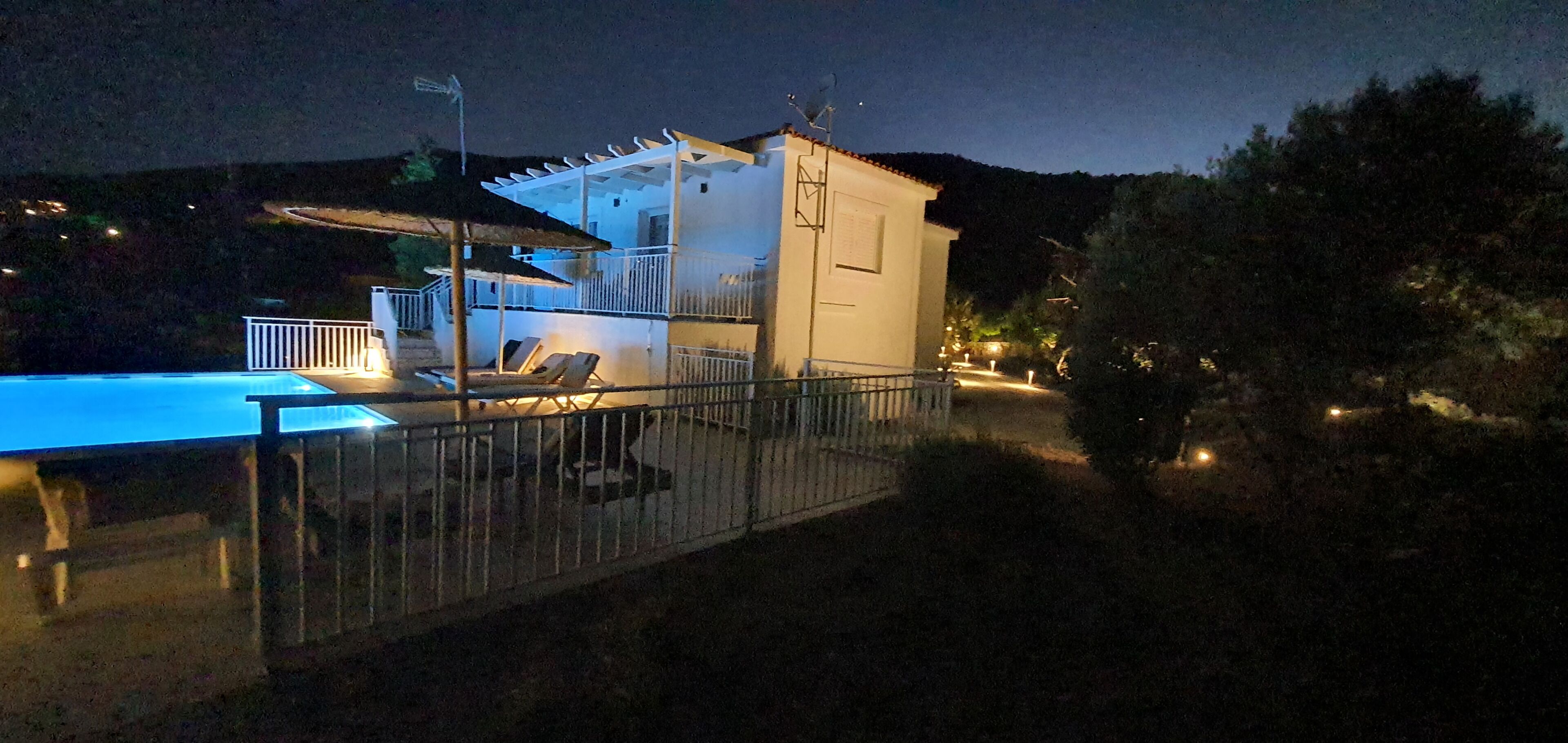 Un edificio con piscina, un patio cubierto y un área cercada.